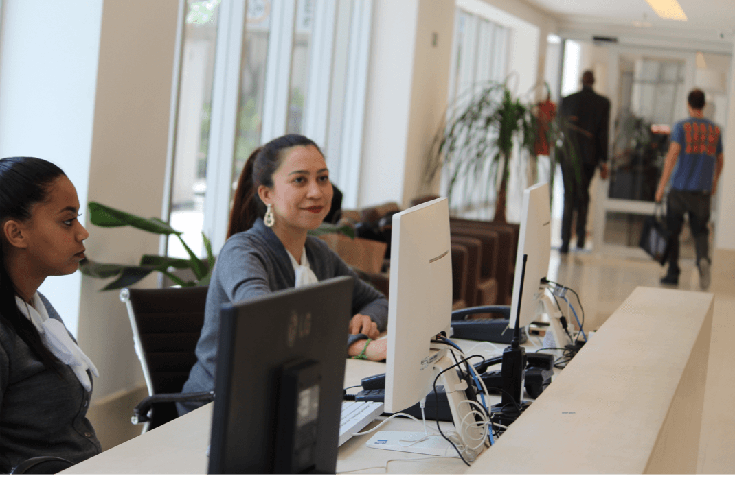 Recepcionistas trabalhando em ambiente corporativo.